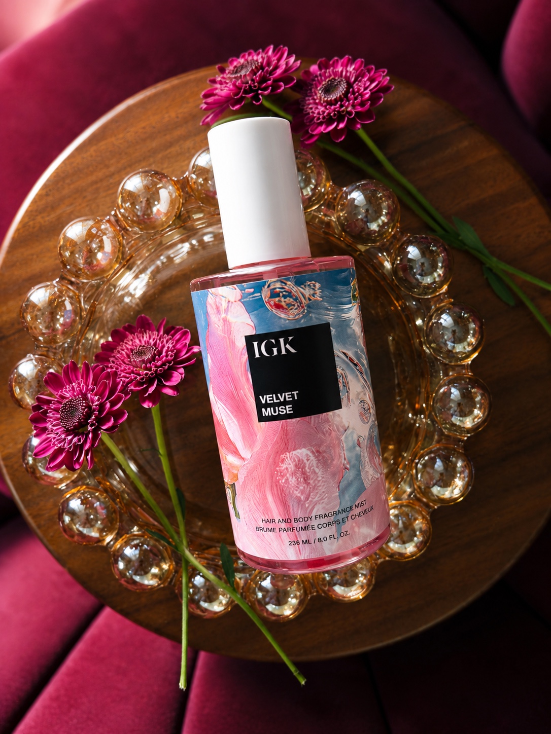 IGK Velvet Muse Hair and Body Fragrance Mist product flatlay with florals — product photography by Brogan Chadwell